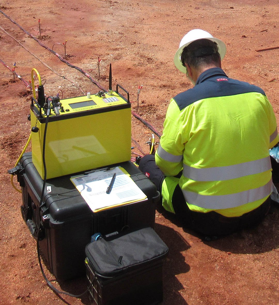 Technician performing Wenner 4-point soil resistivity test with yellow equipment on site. Wenner method for accurate soil resistivity measurement.